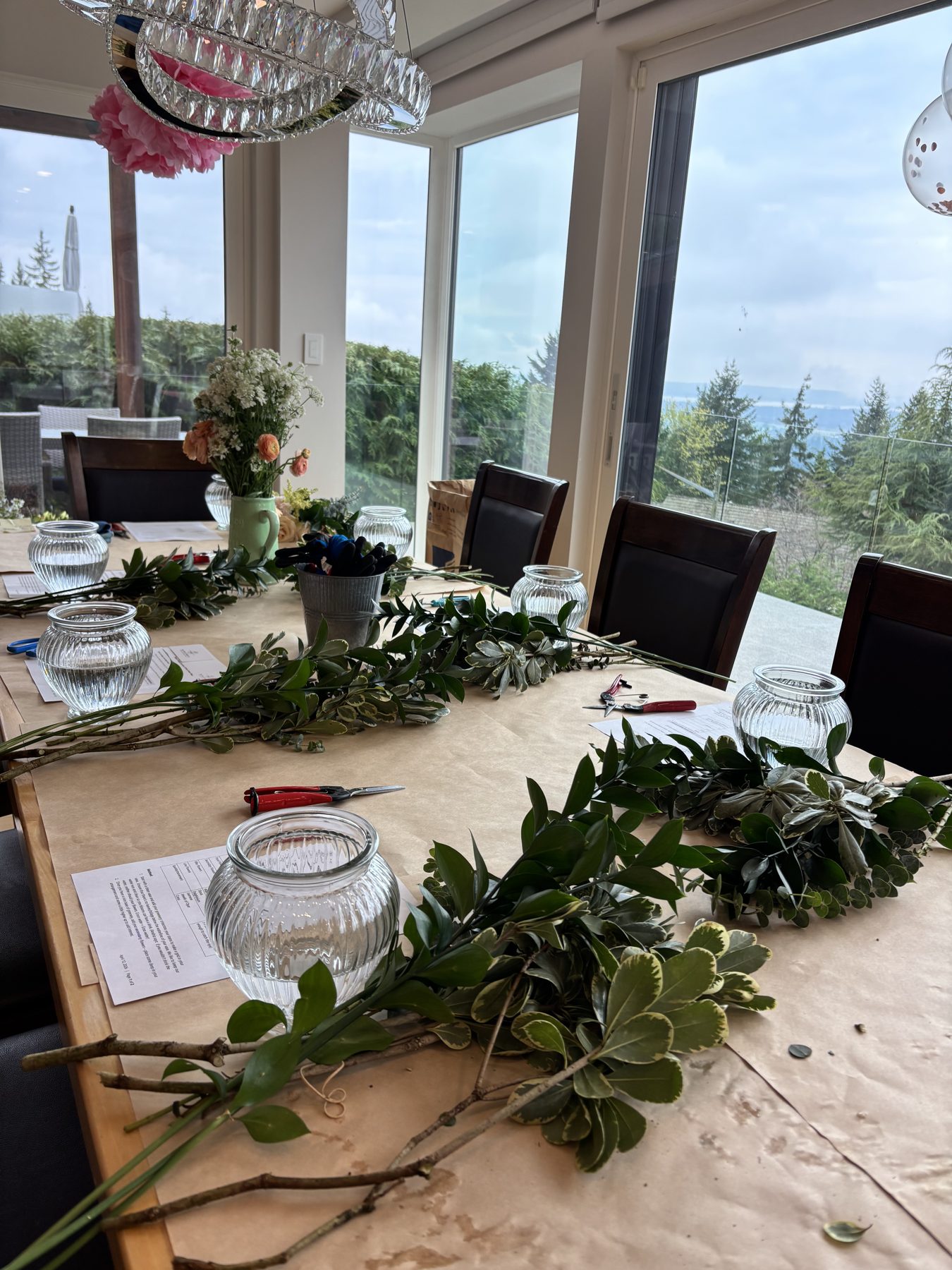 A workshop table set with vases, snips and fresh greenery