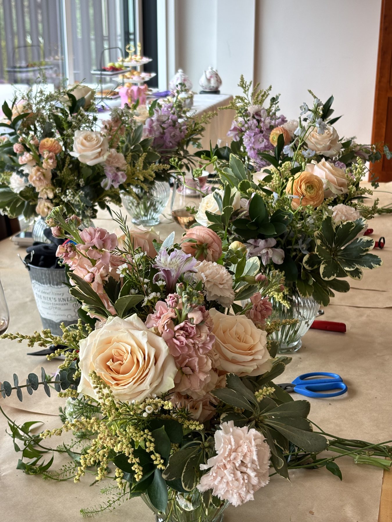 A table lined with finished peach and lavender floral arrangements